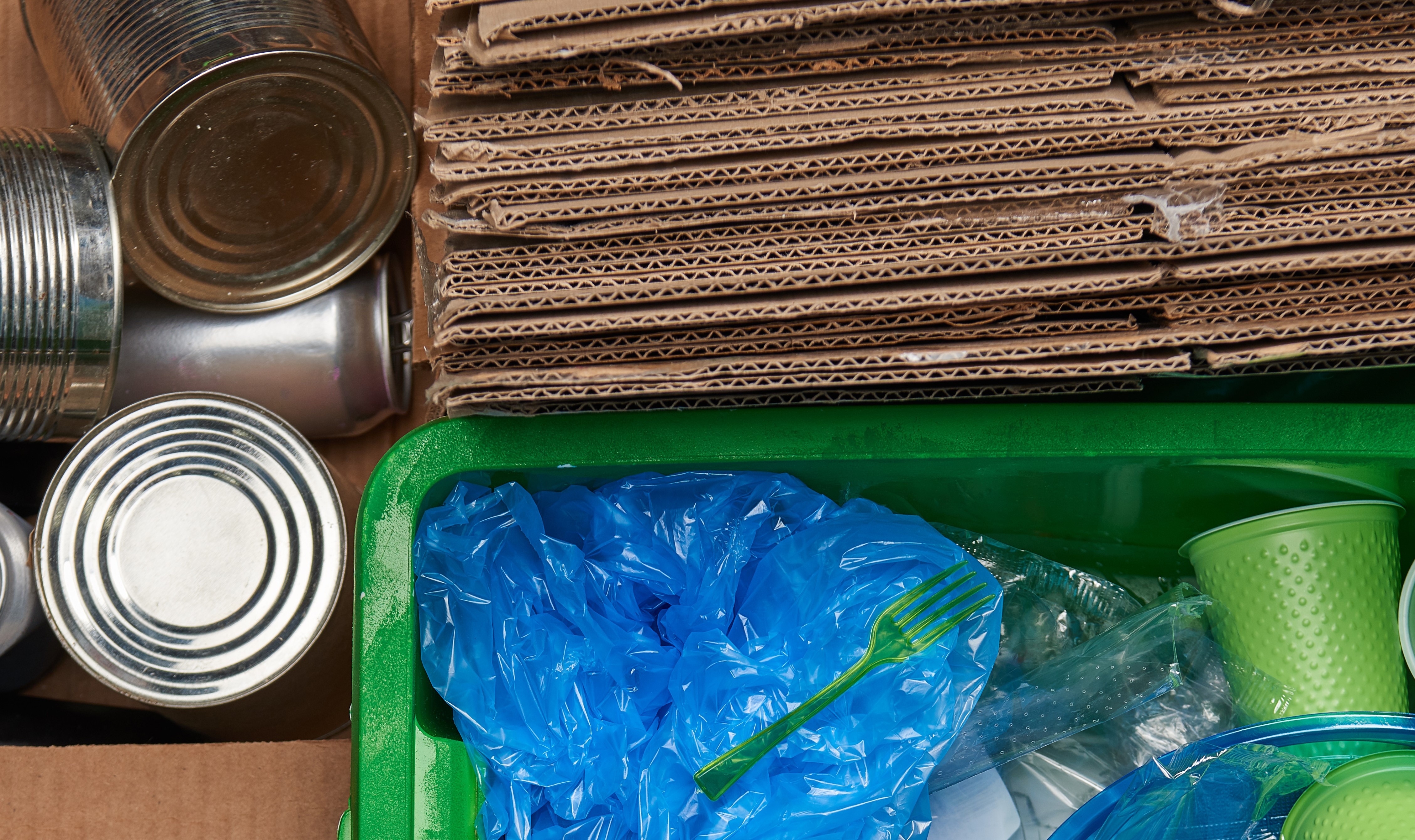 top view of sorted excess waste that is plastic, paper, metal and glass trash