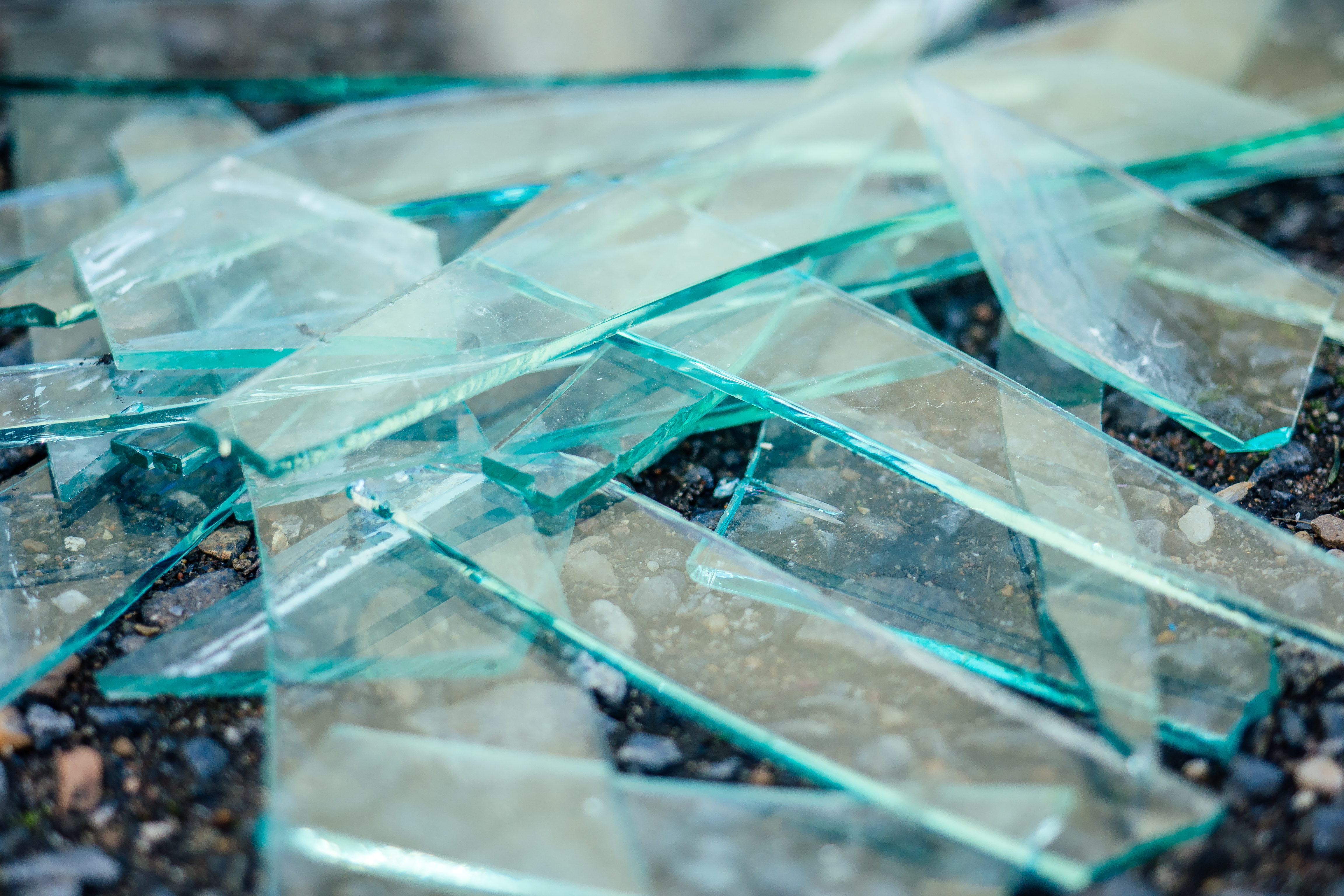 a small pile of broken glass lying on the asphalt